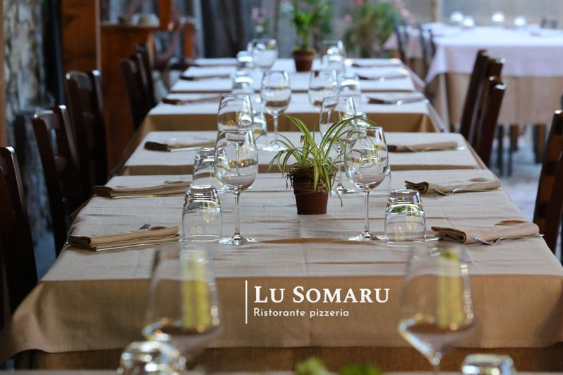 un ristorante con tavoli e sedie è chiamato lu somaru