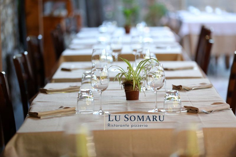 un lungo tavolo con bicchieri e tovaglioli in un ristorante