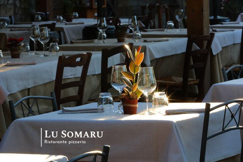 un ristorante con tavoli e sedie è chiamato lu somaru