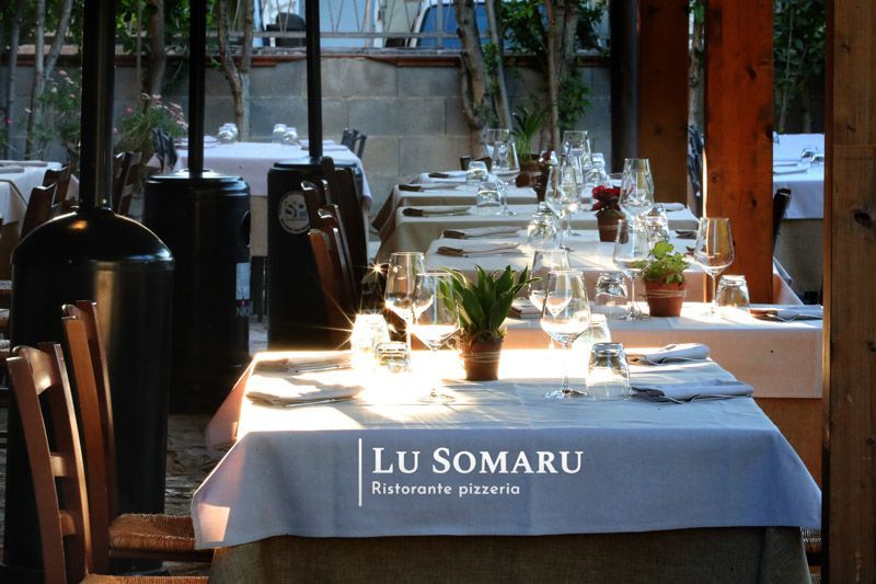 un ristorante con tavoli e sedie è chiamato lu somaru