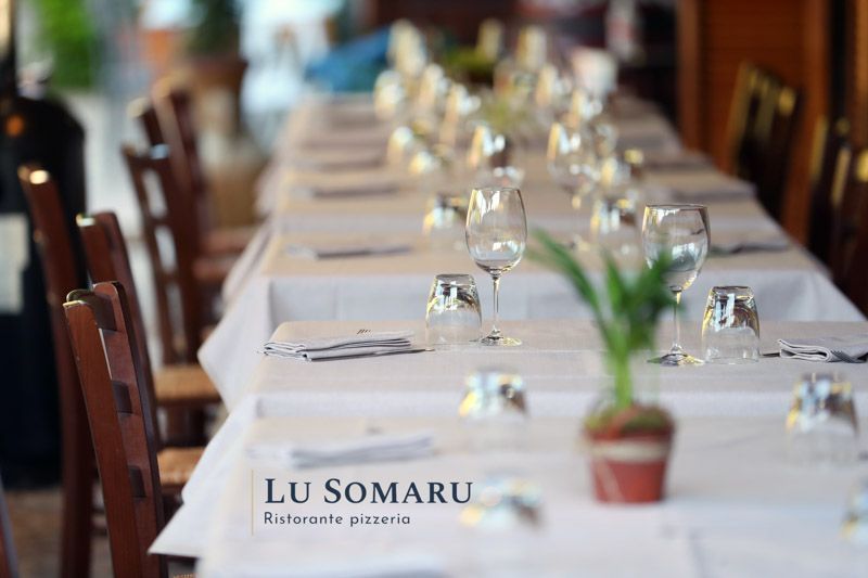 un lungo tavolo in un ristorante con bicchieri e tovaglioli