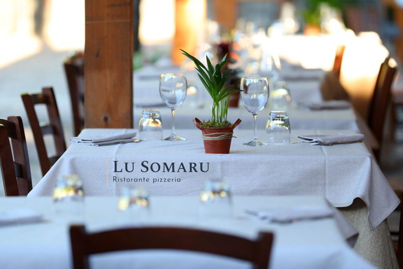 un ristorante è chiamato lu somaru ed è pieno di tavoli e sedie