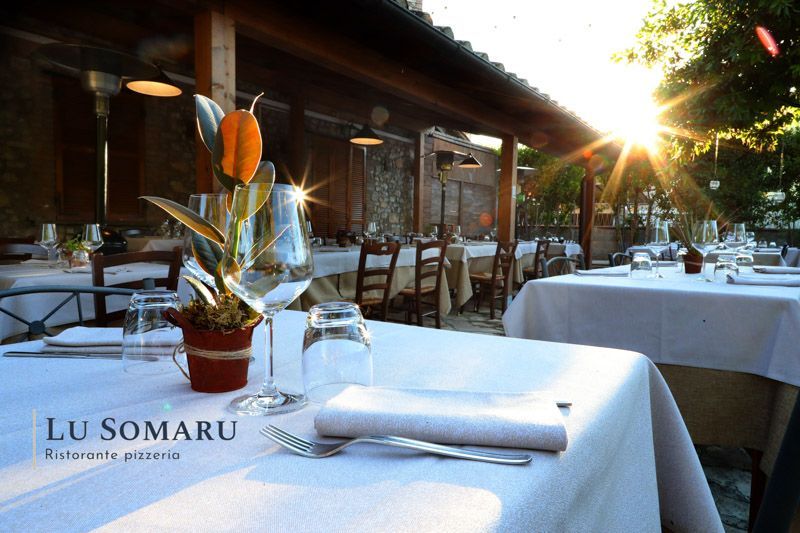 un ristorante con tavoli e sedie è chiamato lu somaru