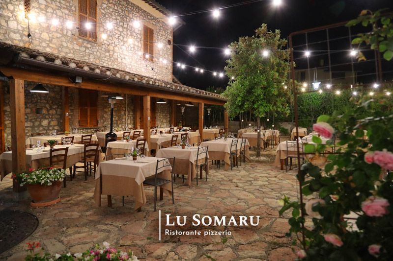 un ristorante con tavoli e sedie è chiamato lu somaru