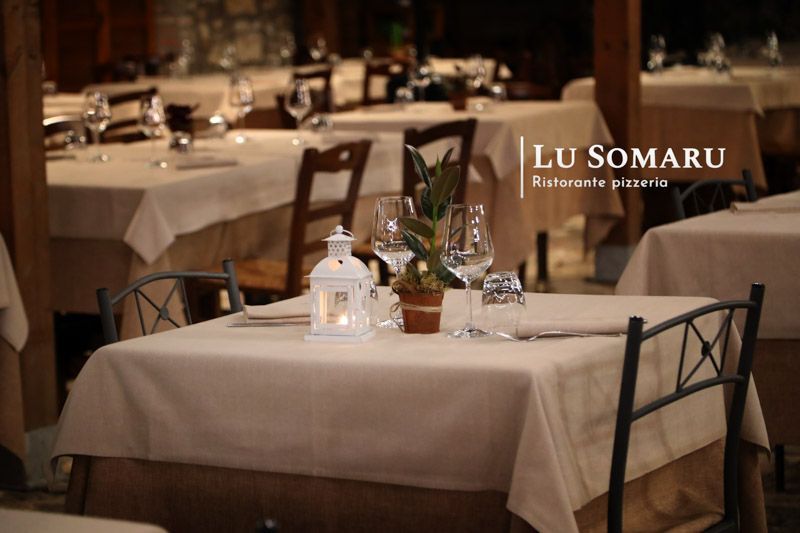 un ristorante con molti tavoli e sedie è chiamato lu somaru