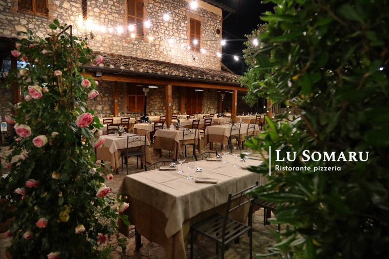 un ristorante con tavoli e sedie è chiamato lu somaru