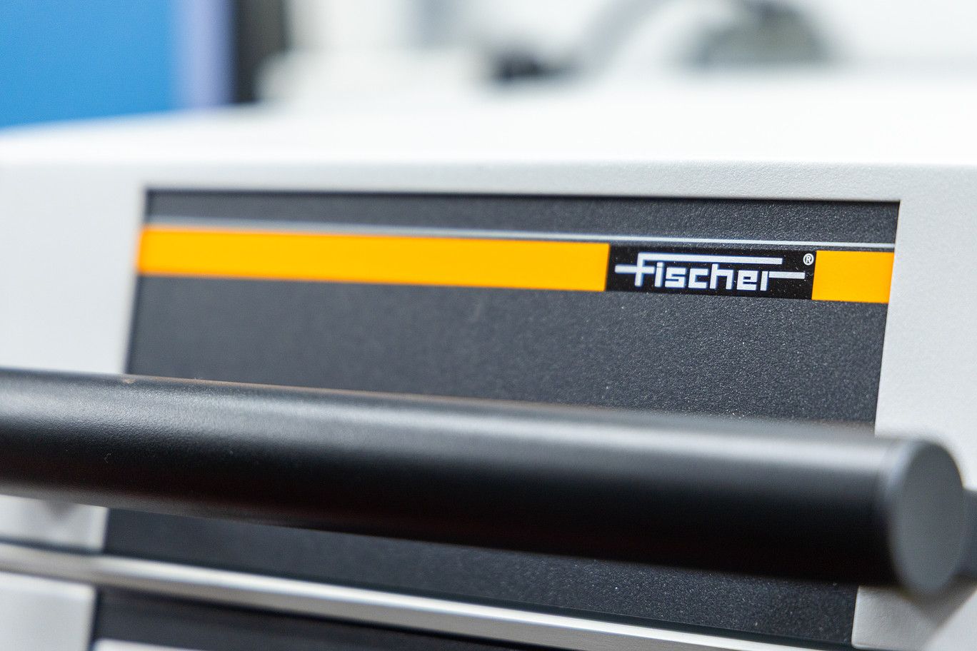 Close-up of a white device panel with a black horizontal handle and a