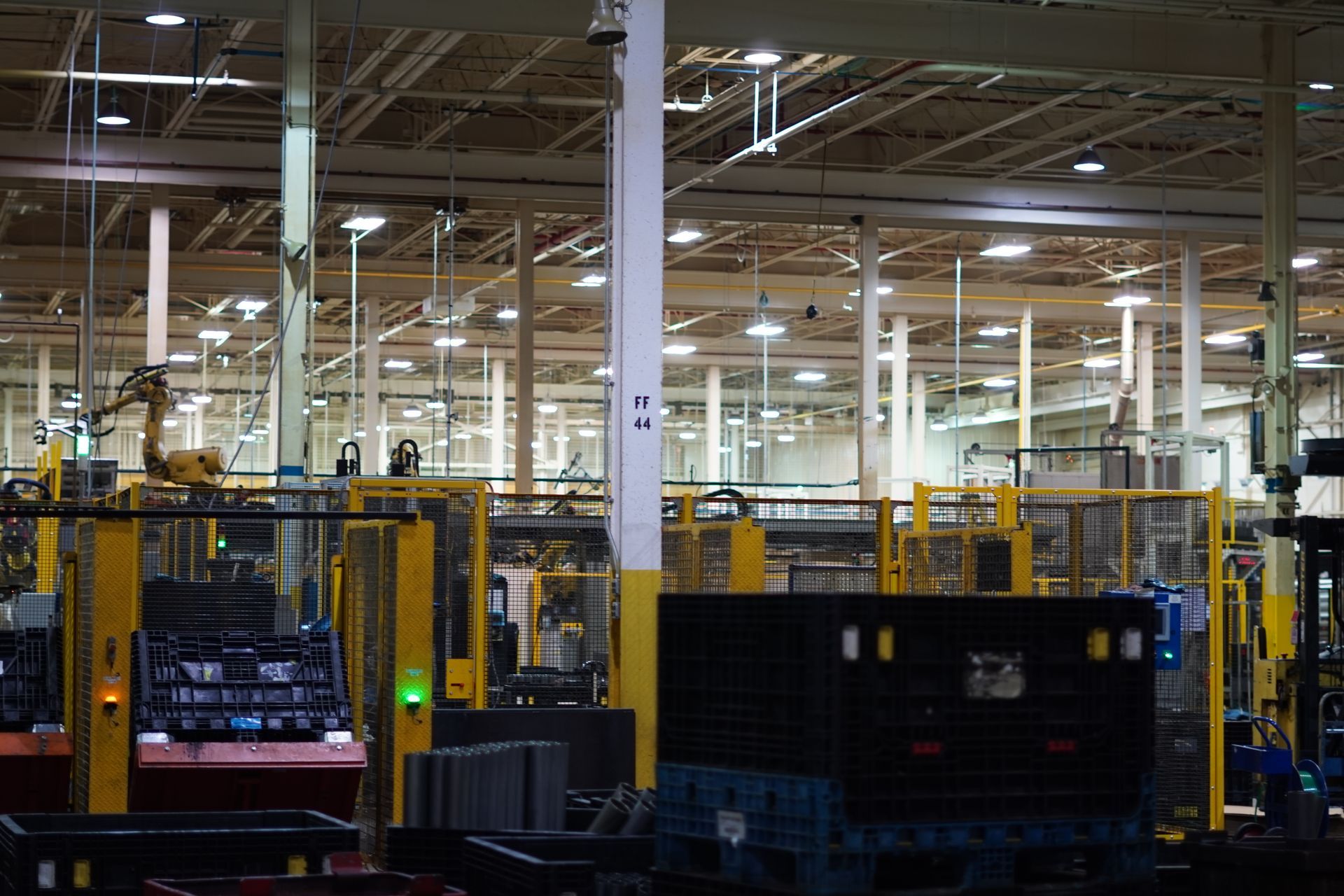 Factory interior with automated machinery and storage containers.