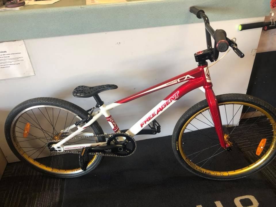 Red and White Free Agent BMX Bike with Gold Rims, Sitting on A Black Mat — City Centre Cycles in Berserker, QLD