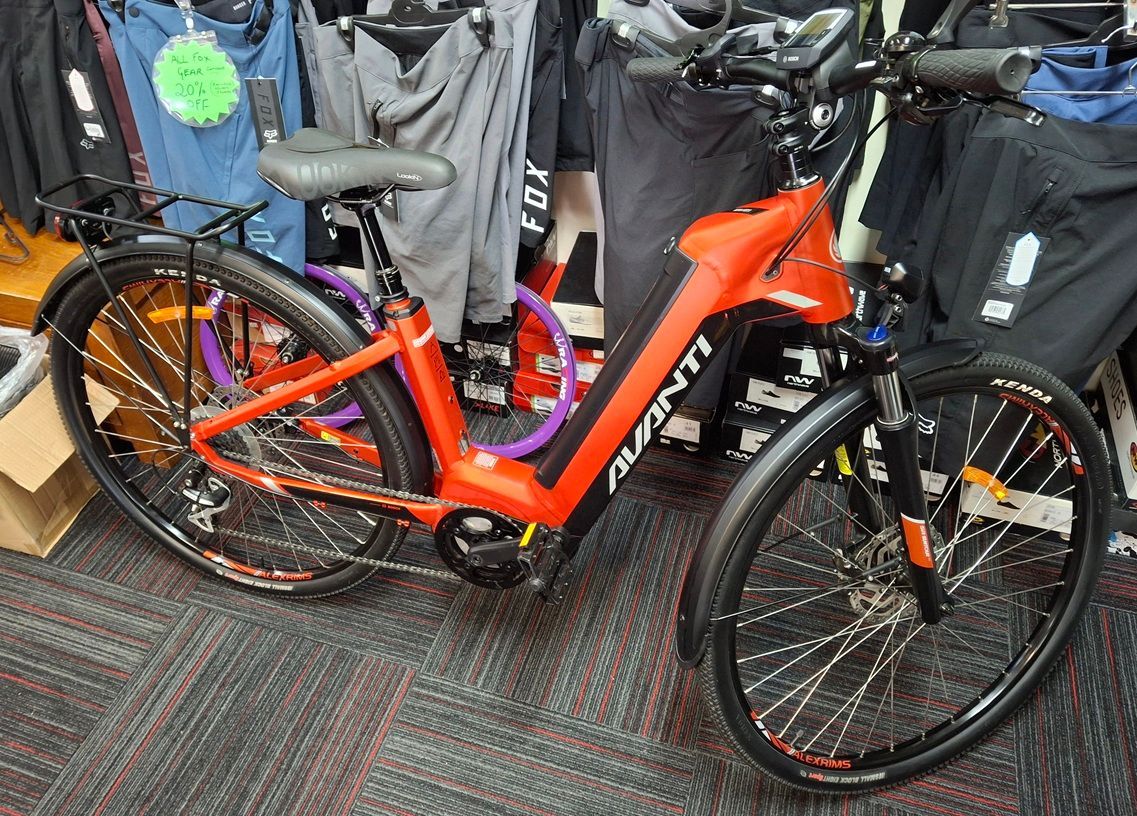 Orange electric bicycle indoors, displayed among other bikes and gear— City Centre Cycles in Berserker, QLD