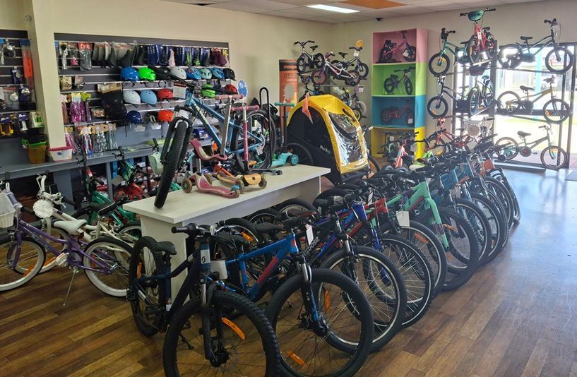 Bike shop with rows of bicycles, repair tools, and accessories in a bright showroom — City Centre Cycles in Berserker, QLD