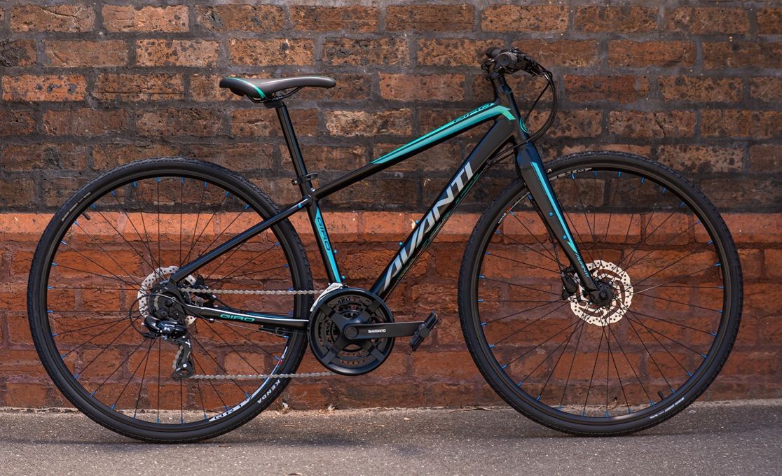 Black and Teal Mountain Bike Against a Brick Wall — City Centre Cycles in Berserker, QLD