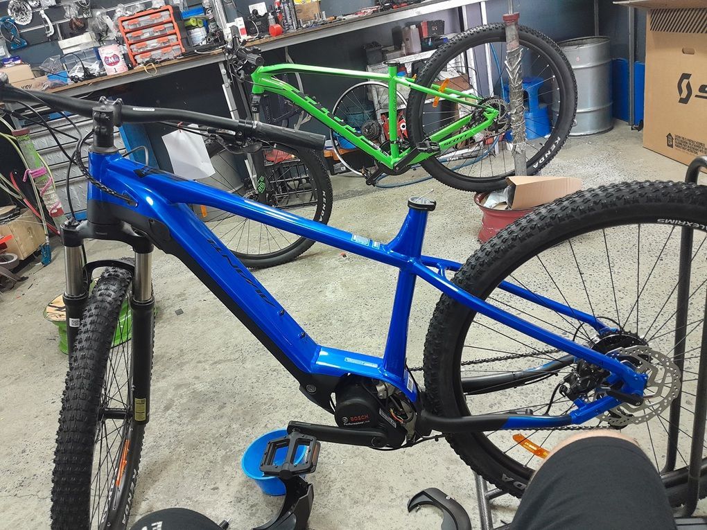 Blue Mountain Bike in A Workshop, with A Green Bike and Tools in The Background — City Centre Cycles in Berserker, QLD