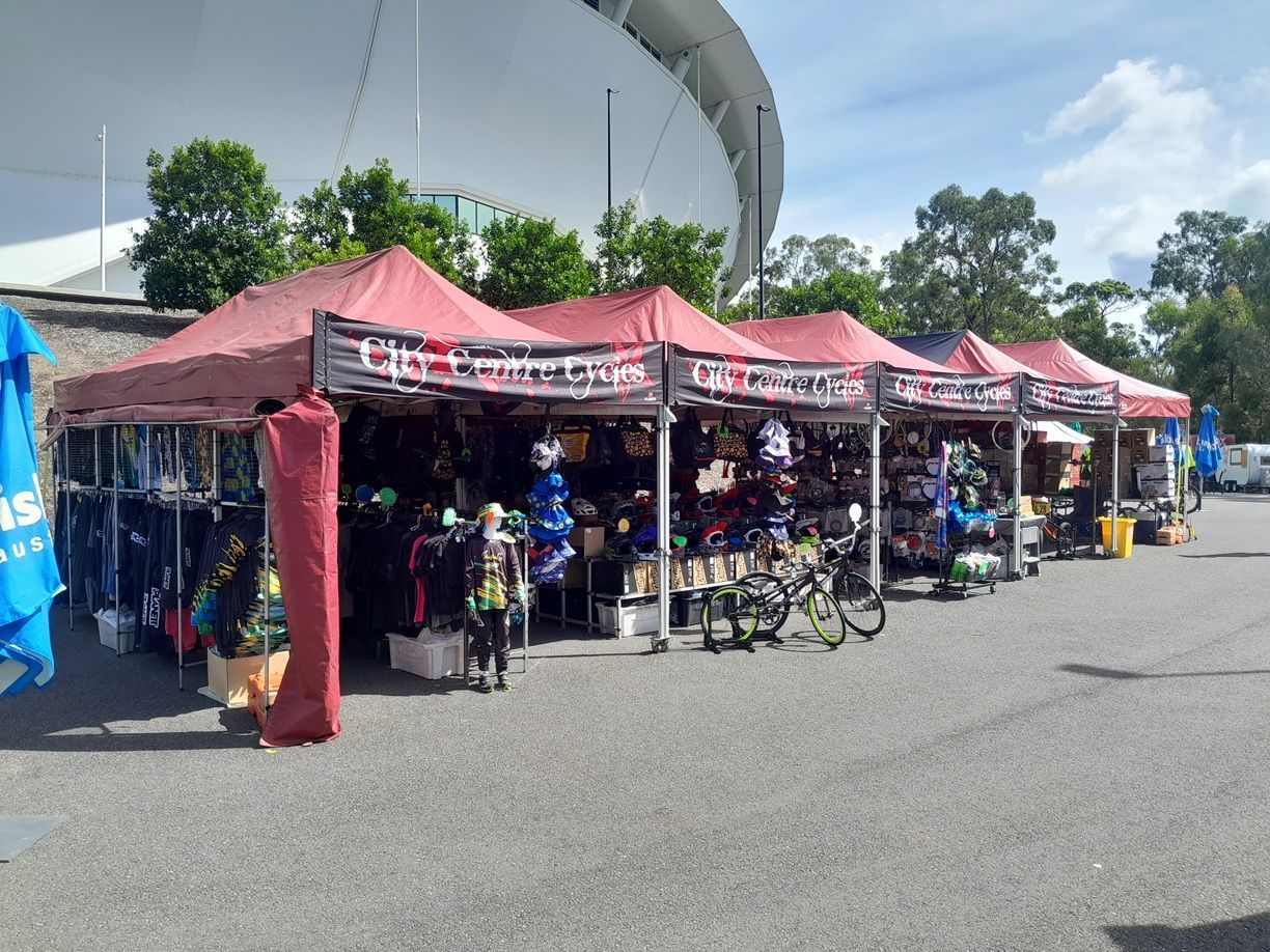 Red Vendor Tents Lining a Roadside Market Stall — City Centre Cycles in Berserker, QLD
