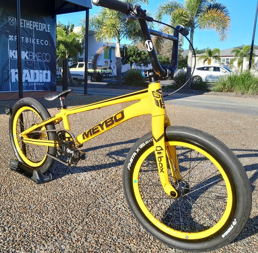 Yellow BMX Bike Parked on Asphalt Beside a Street with Palm Trees — City Centre Cycles in Berserker, QLD