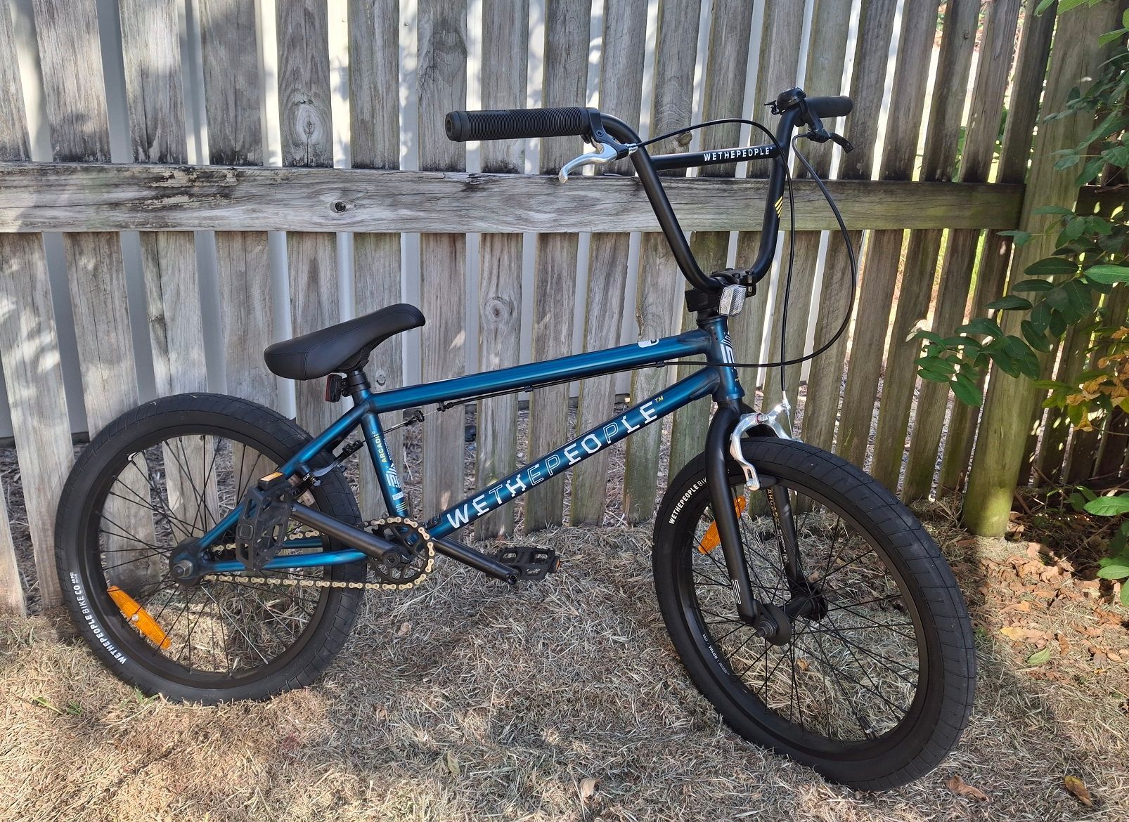 Blue BMX bike leaning against a wooden fence on gravel — City Centre Cycles in Berserker, QLD