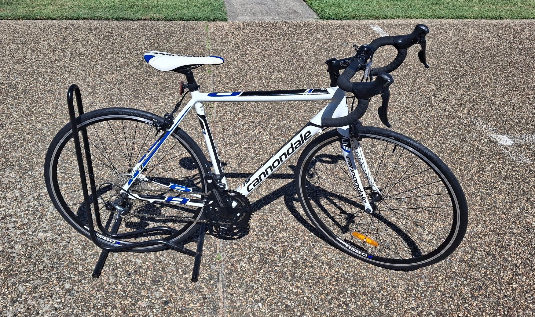 White and blue road bike with drop handlebars parked on a gravel path outdoors — City Centre Cycles in Berserker, QLD