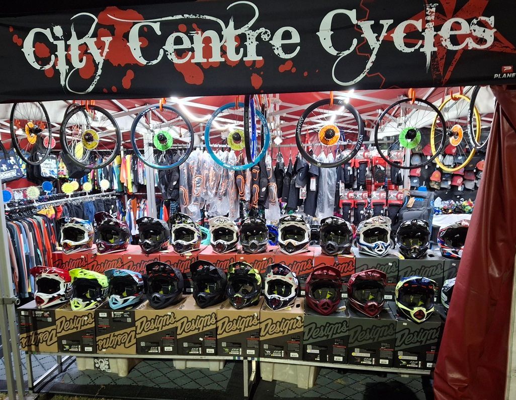 Colourful bicycle shop display with rows of helmets and accessories under a “City Centre Cycles” sign — City Centre Cycles in Berserker, QLD
