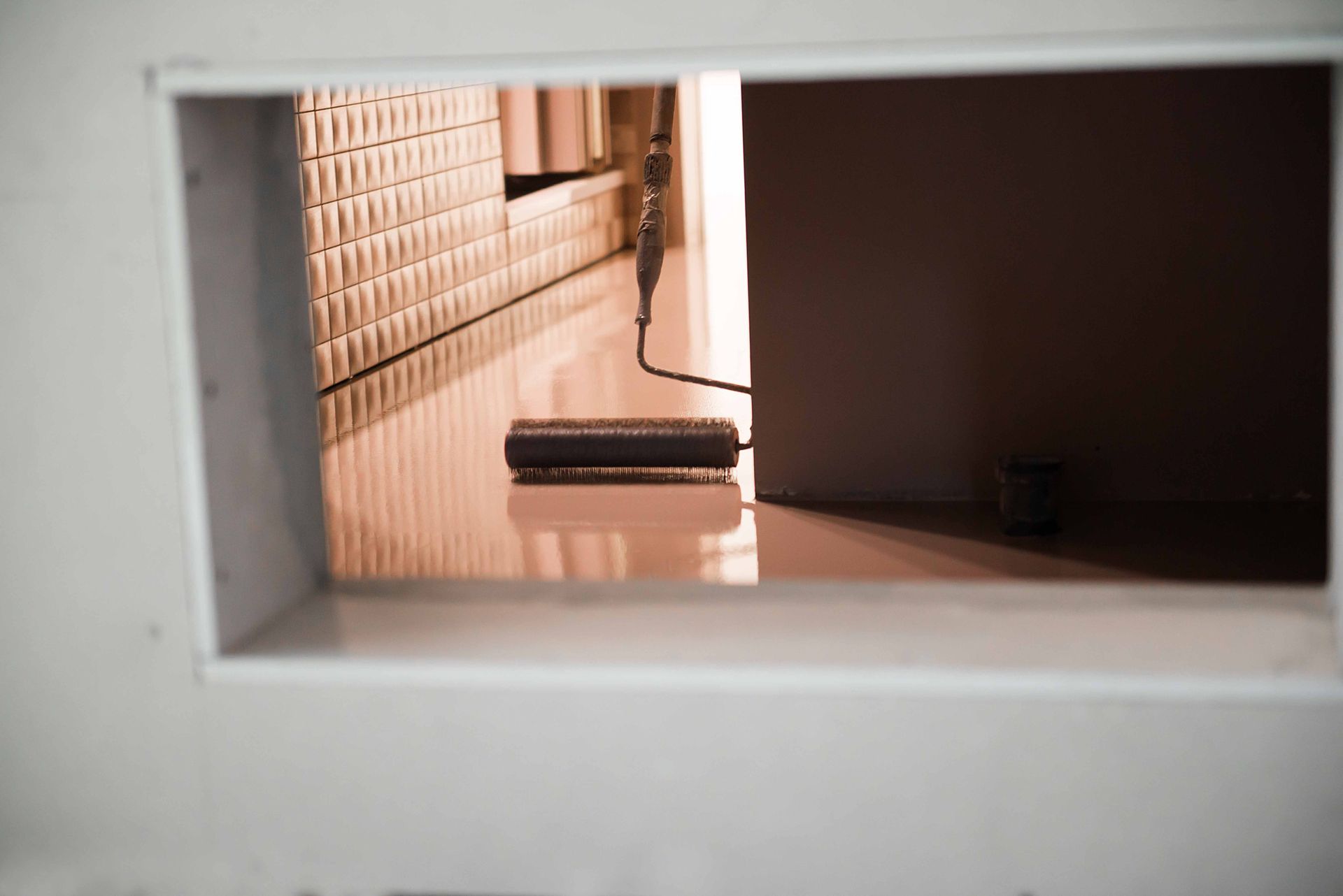 Paint roller on a shiny floor, viewed through a rectangular opening. Paint roller on a shiny floor, viewed through a rectangular opening.