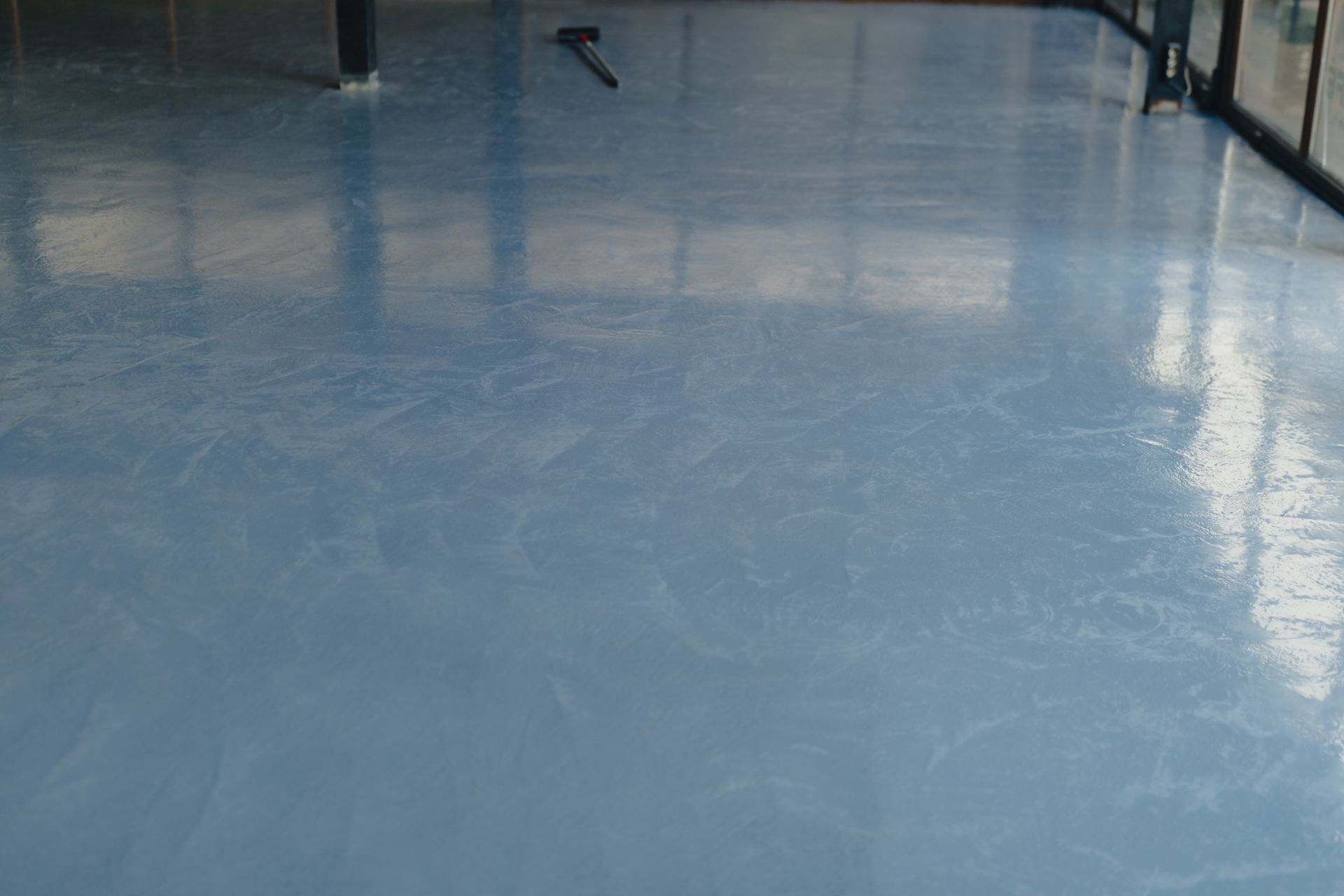 Blue epoxy floor reflecting light; interior space.