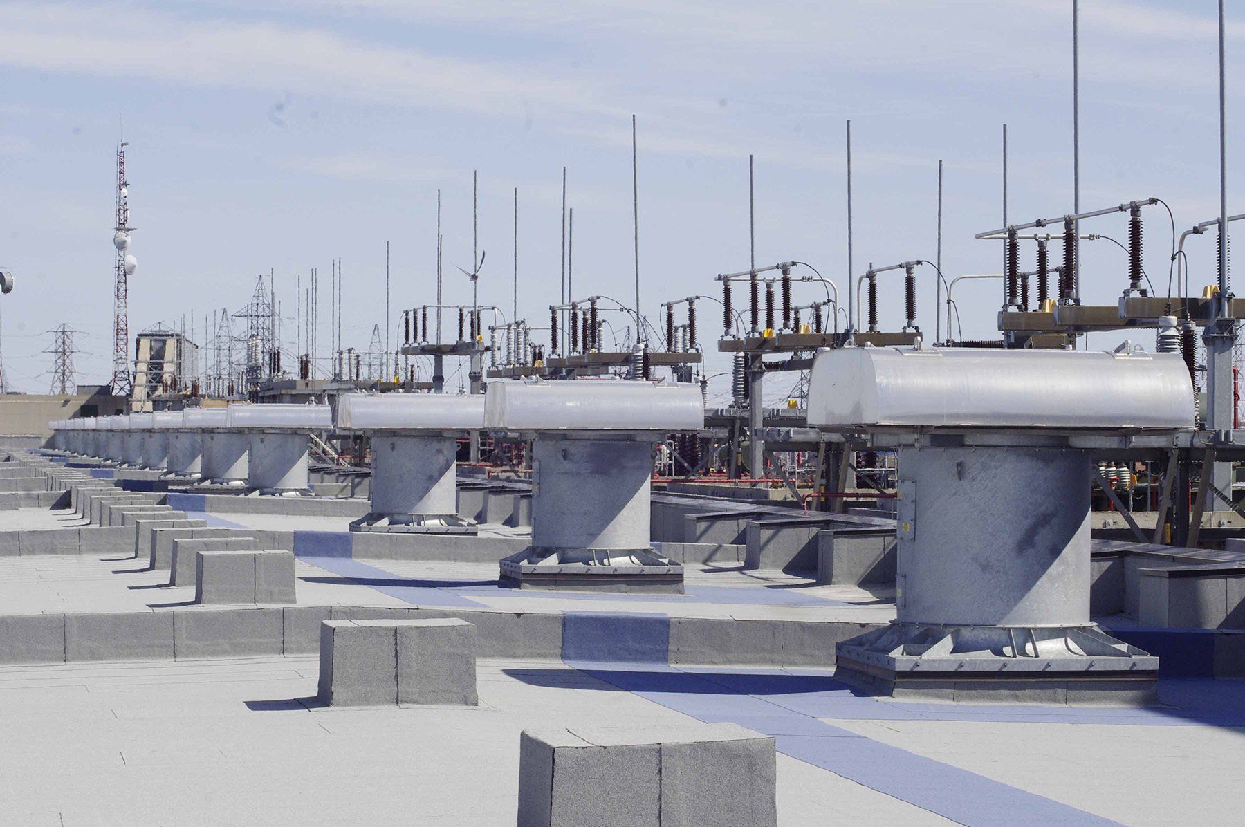 Power plant equipment on a flat roof, with lightning rods and insulators.