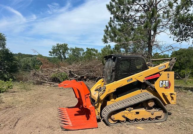 Skid steer with grapple attachment clearing brush and trees in Southwest Wisconsin.