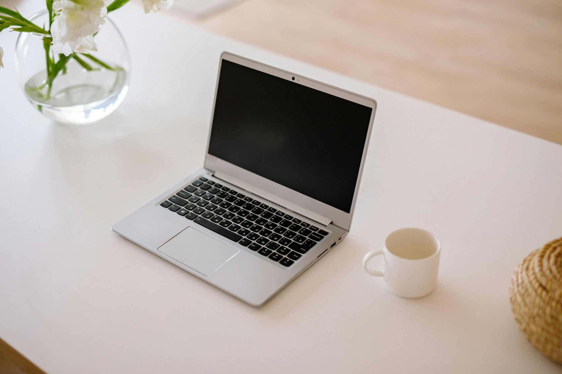 Person typing on a laptop at a desk, with a web page open on the screen.