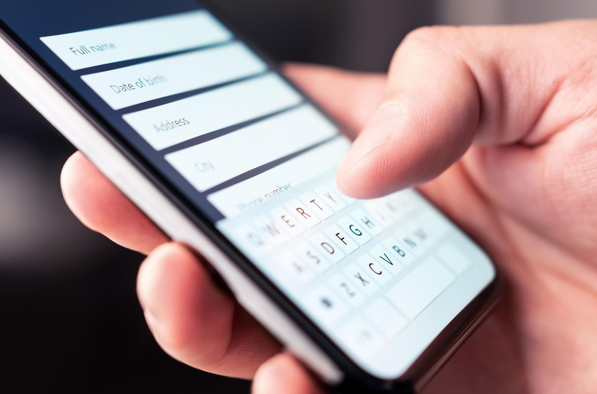 A person is typing on a cell phone with their finger.