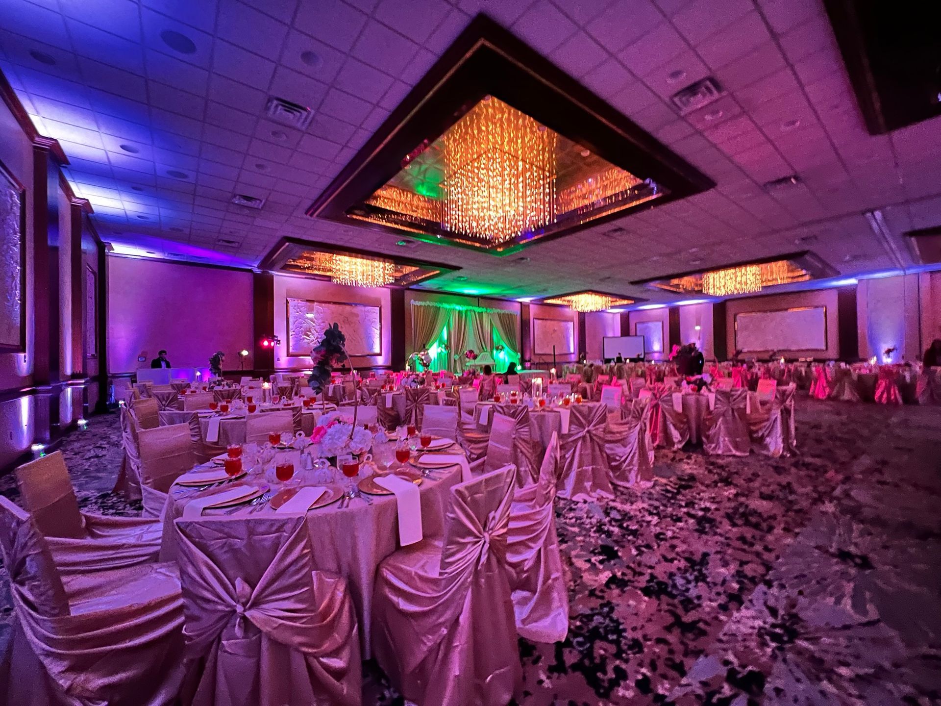 A large ballroom with tables and chairs set up for a wedding reception.