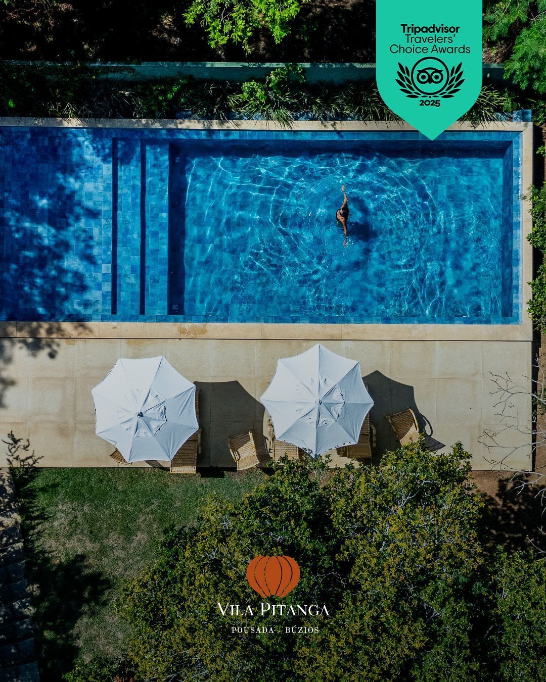 Piscina com pessoa, guarda-sóis e logotipo da Villa Pitanza.