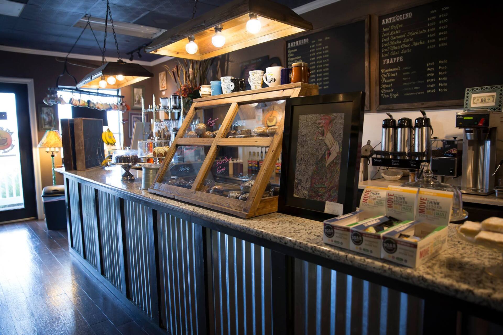 A coffee shop with a long counter and a menu on the wall.