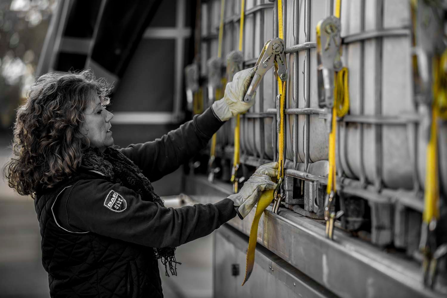Logistics photography worker securing straps on a cargo truck at a loading dock