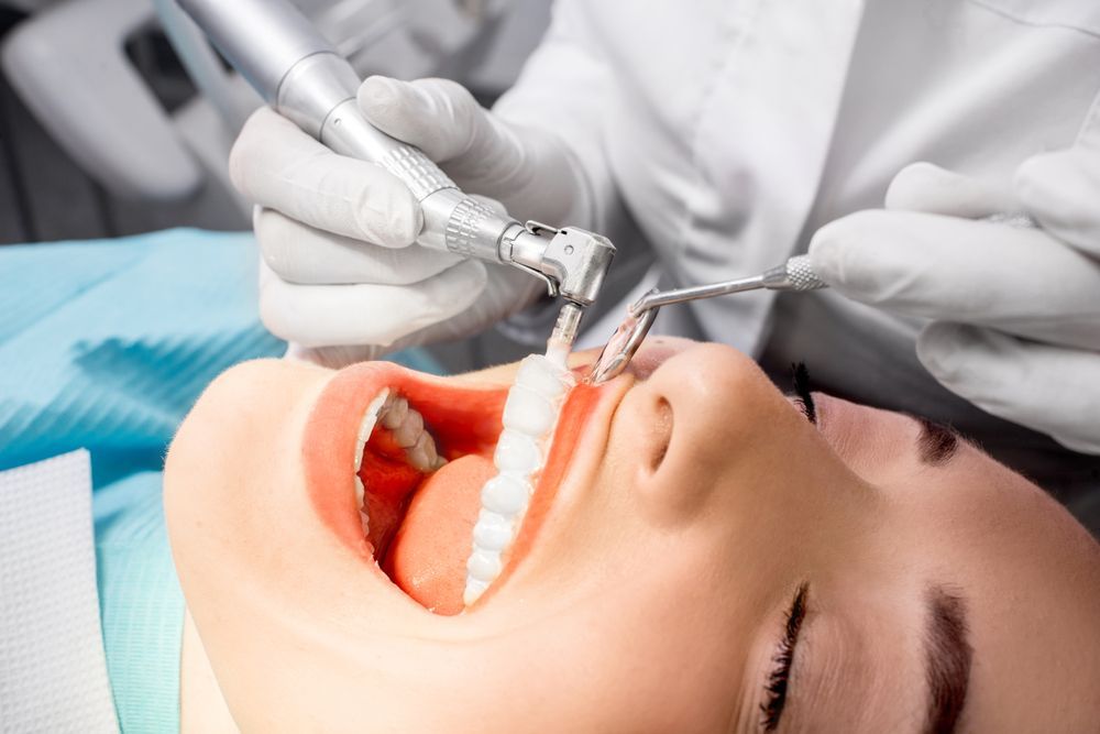 A Woman Is Getting Her Teeth Cleaned By A Dentist — BB Dental Cairns Dentists Dental In Earlville, QLD