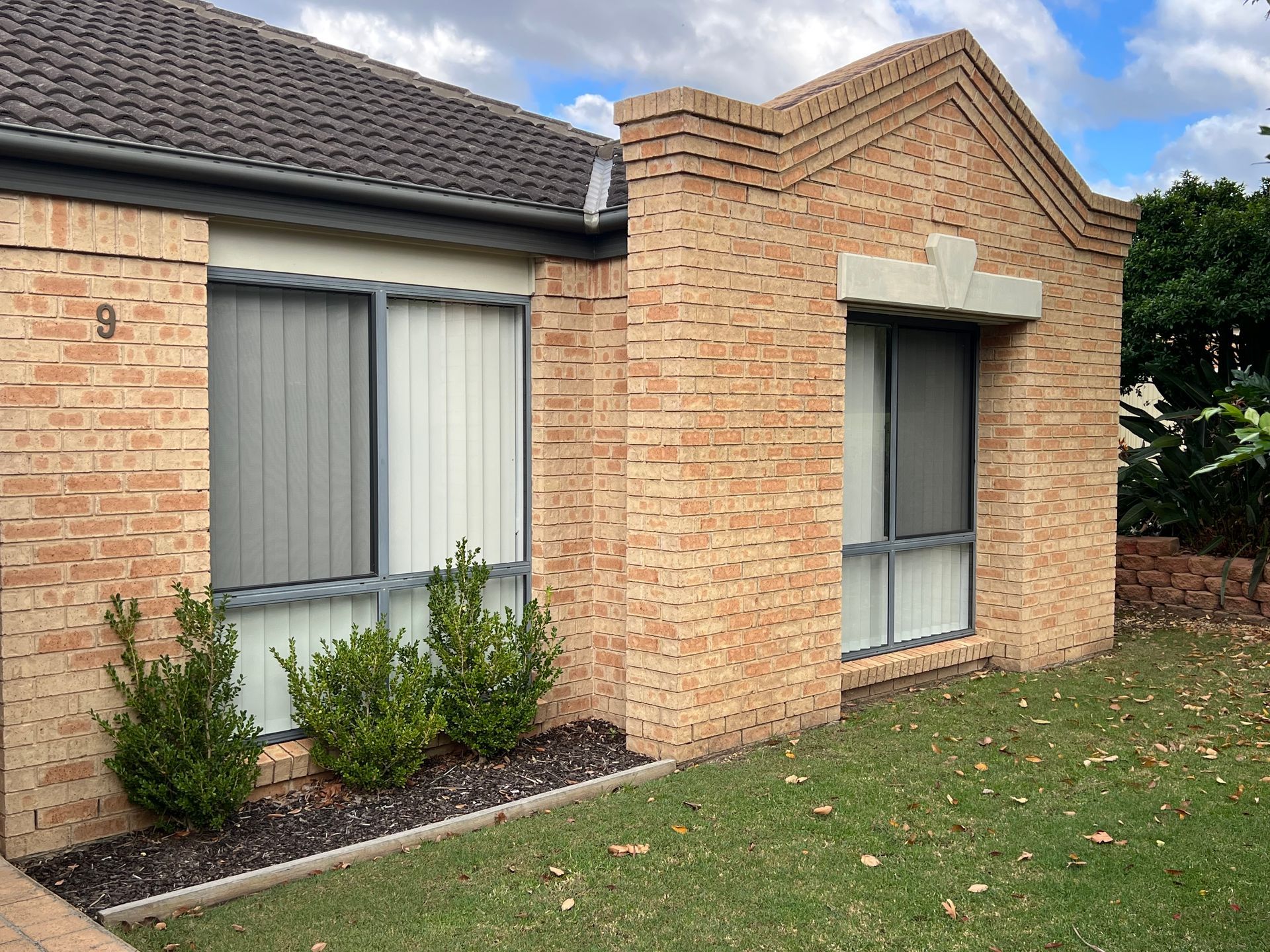 A Row of White Vertical Blinds in A Room — Bay Blinds & Doors in Bateau Bay, NSW