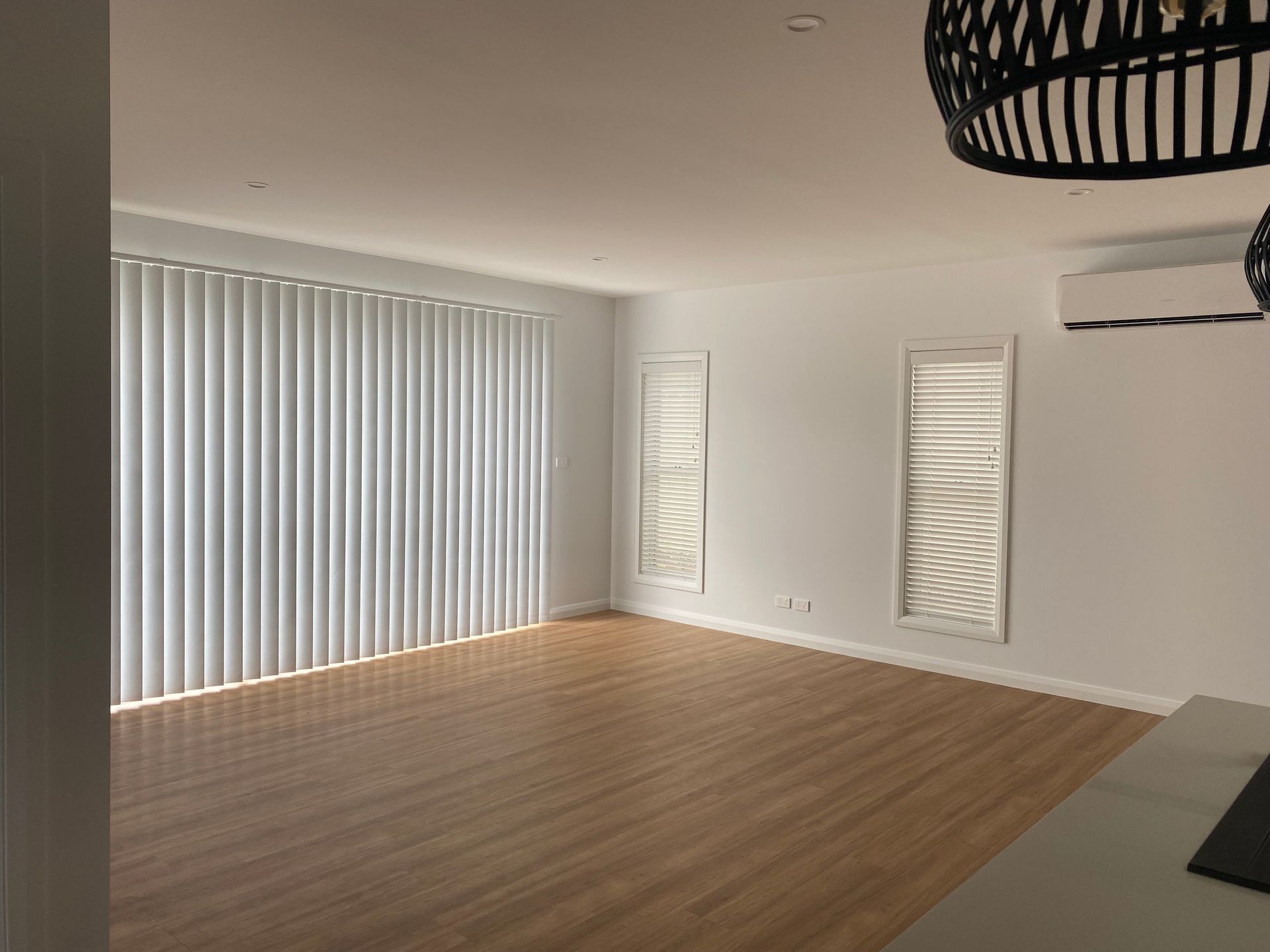 A Gray and White Striped Roman Shade Is Hanging on A Window — Bay Blinds & Doors in Bateau Bay, NSW