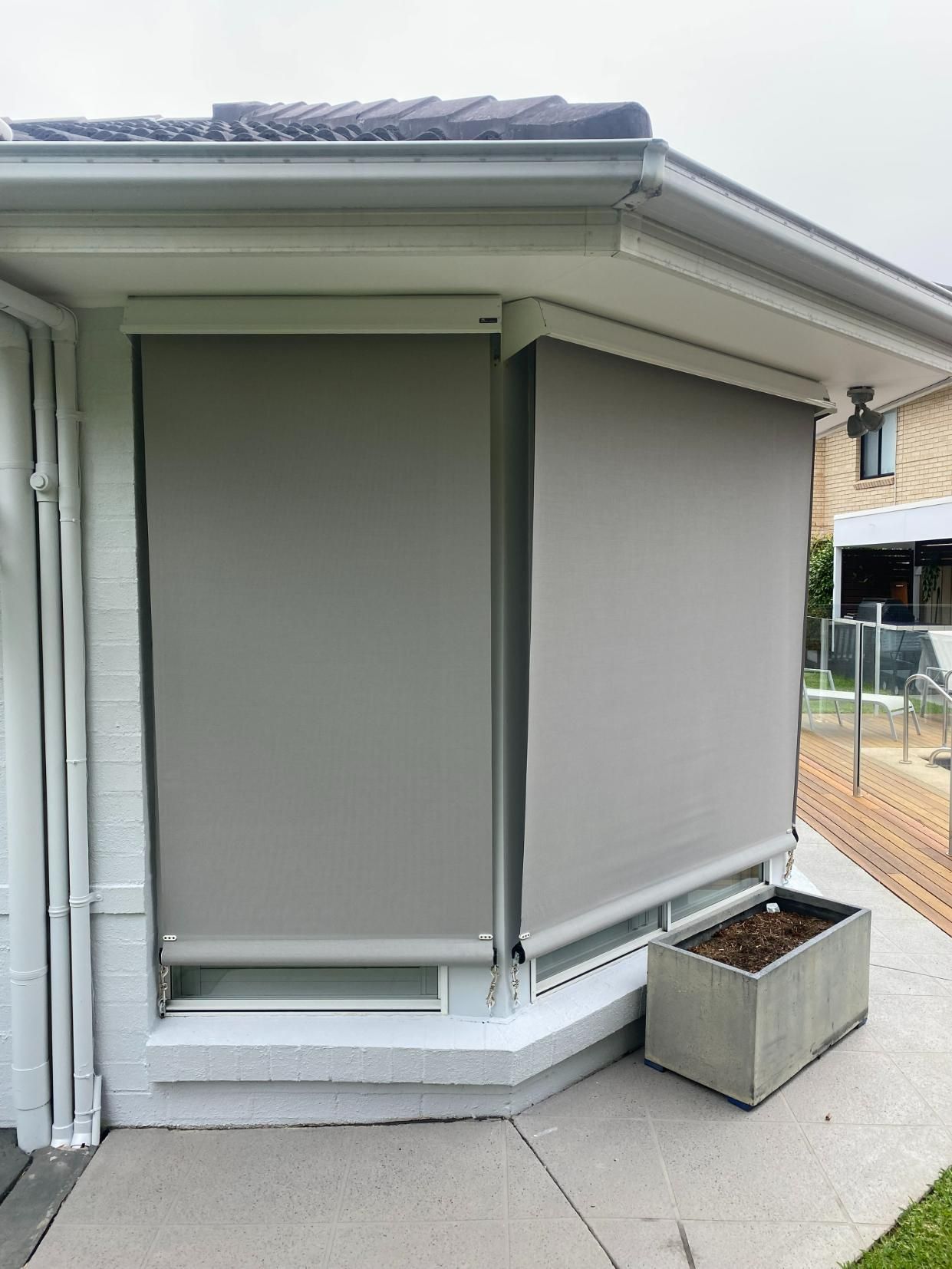 A House with A Deck and A Fence with Blinds on It — Bay Blinds & Doors in Bateau Bay, NSW