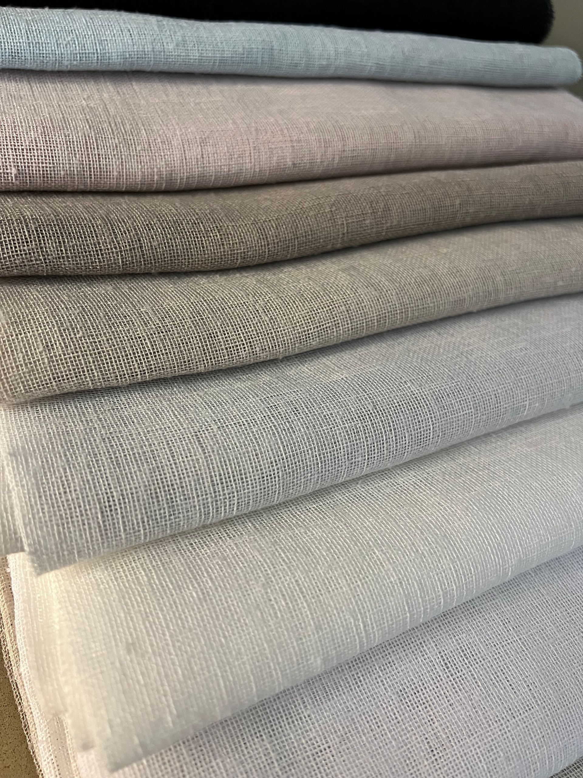 Stack of folded neutral-colored fabric or towels in gray and beige tones