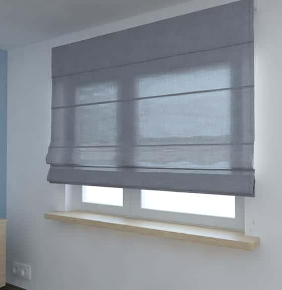 A Gray Roman Shade Is Hanging on A Window in A Room — Bay Blinds & Doors in Bateau Bay, NSW