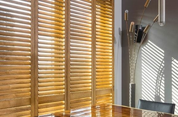 The Sun Is Shining Through the Blinds of A Window — Bay Blinds & Doors in Bateau Bay, NSW