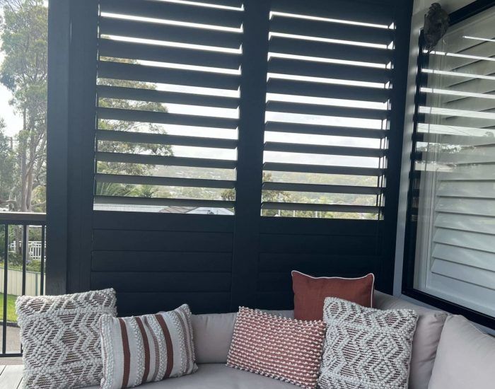 A White Car Is Parked in Front of A White Building with Shutters on It — Bay Blinds & Doors in Bateau Bay, NSW