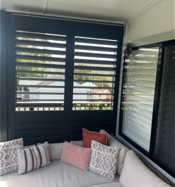 A Close up Of a Window with White Blinds on It — Bay Blinds & Doors in Bateau Bay, NSW