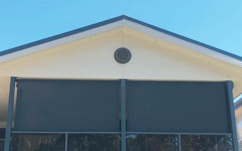 A house with a screened in porch and a blue roof.