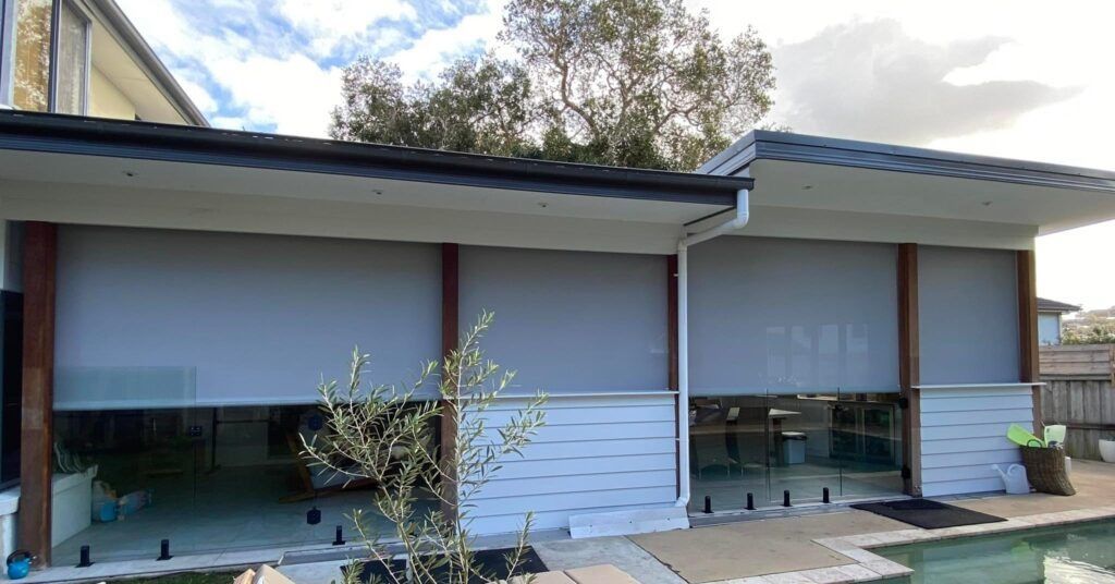 A House With A Swimming Pool In The Backyard And A Patio — Bay Blinds & Doors in Bateau Bay, NSW