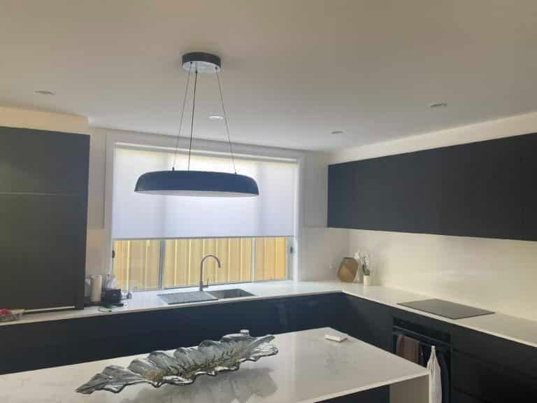 A Kitchen with Black Cabinets , White Counter Tops , a Sink , and A Bowl on The Counter — Bay Blinds & Doors in Bateau Bay, NSW