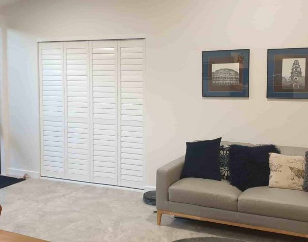 A Living Room with A Couch and Two Pictures on The Wall — Bay Blinds & Doors in Wyee, NSW