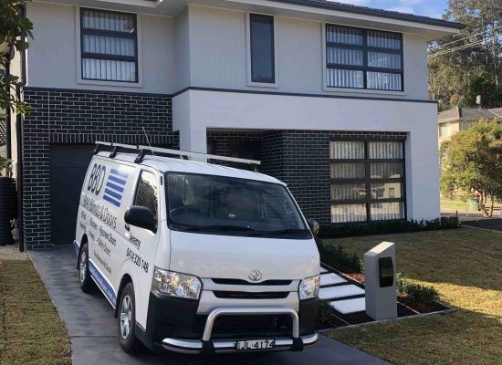 A White Van Is Parked in Front of A House — Bay Blinds & Doors in Wyee, NSW