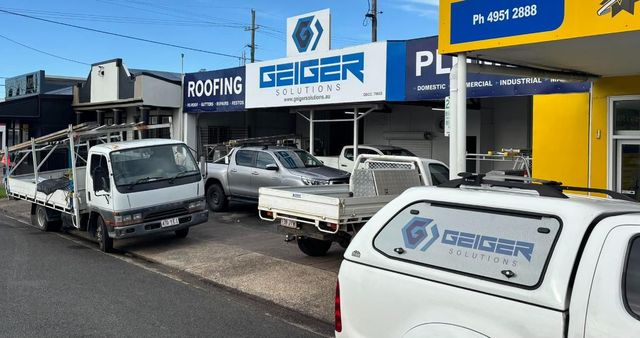 A Row of Trucks Are Parked in Front of a Building — Geiger Solutions In Mackay, QLD