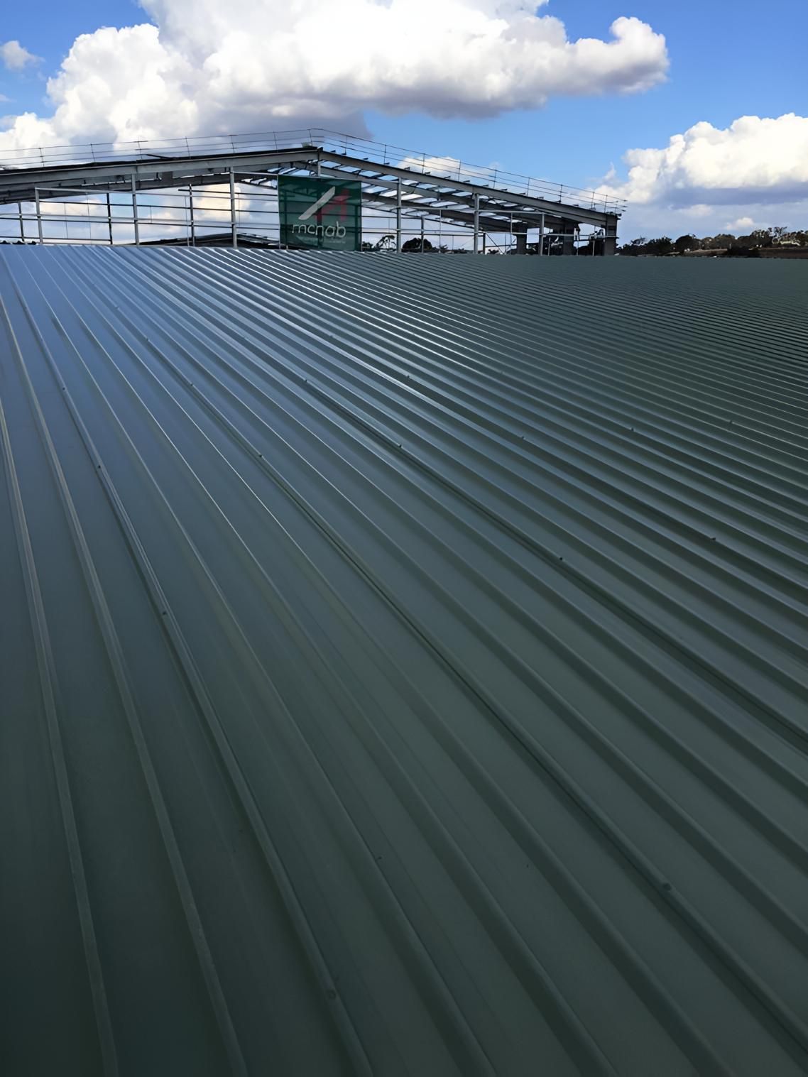 A Green Metal Roof With a Blue Sky in the Background — Geiger Solutions In Clermont, QLD