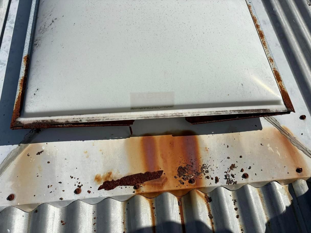 A Rusty Roof With a White Skylight on Top of It — Geiger Solutions In Mackay, QLD