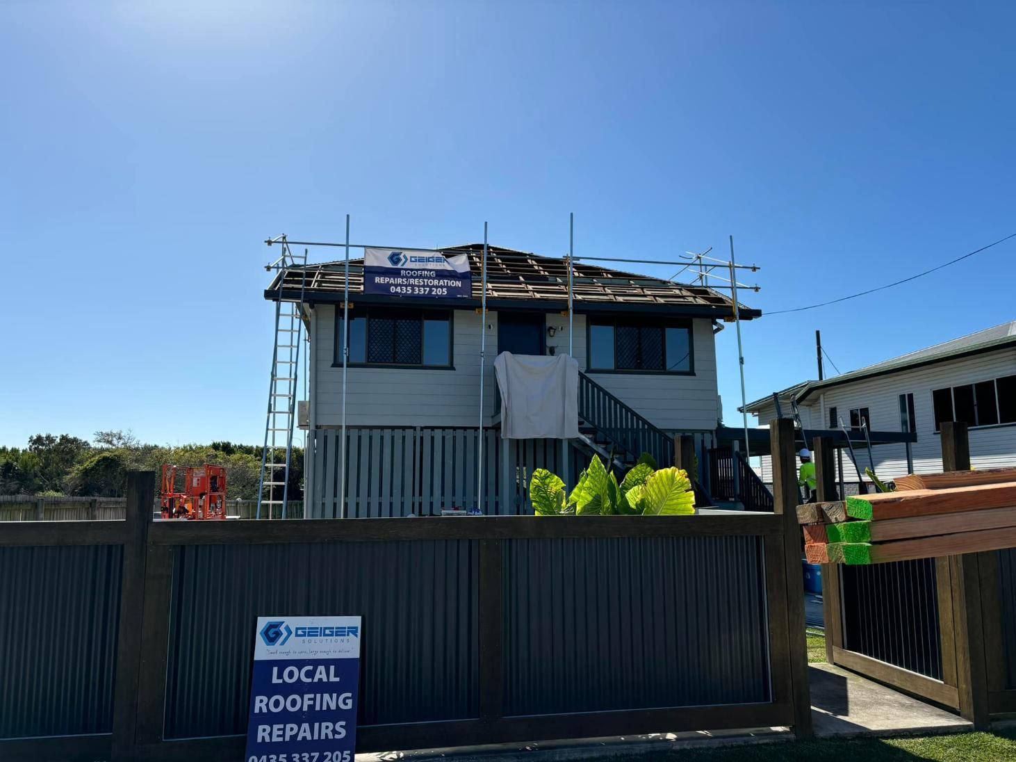 A House Under Construction With a Sign That Says Local Roofing Repairs — Geiger Solutions In Mackay, QLD